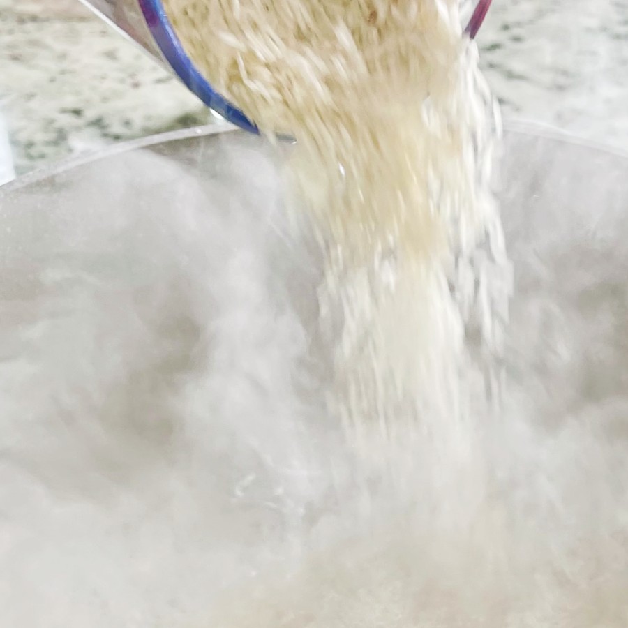 adding rice to boiling water