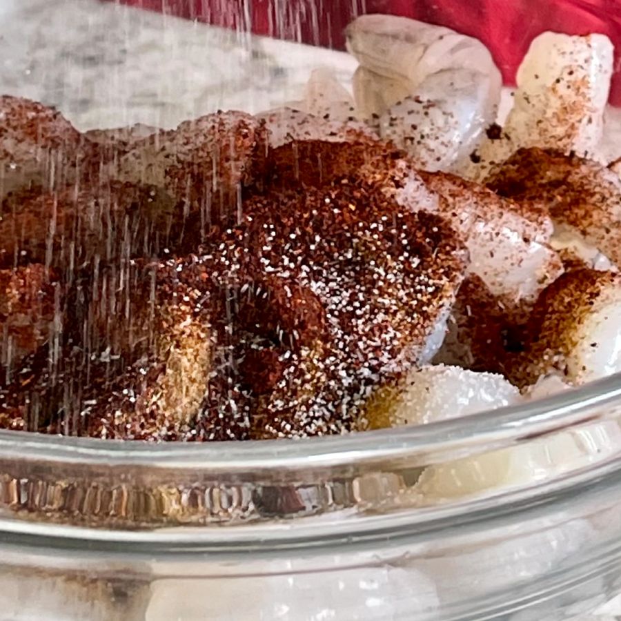 adding seasonings to shrimp