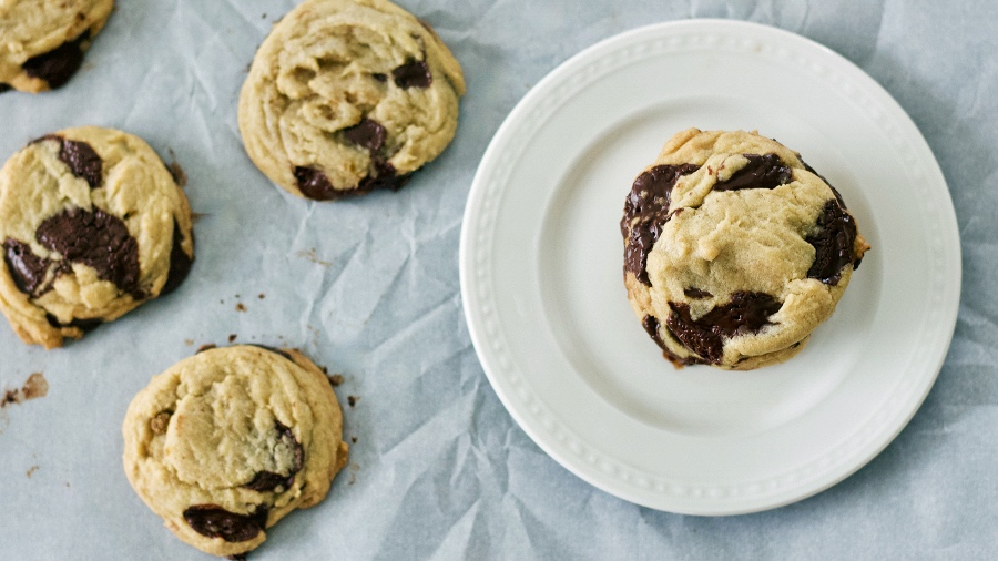 dark chocolate chip cookies on parchment and plate