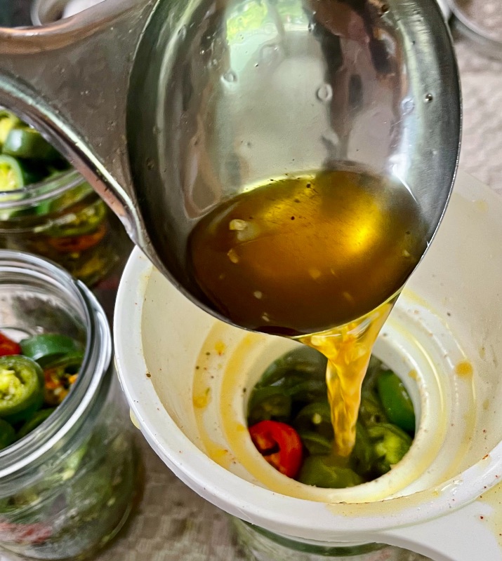 filling jars of Jalapenos with brine