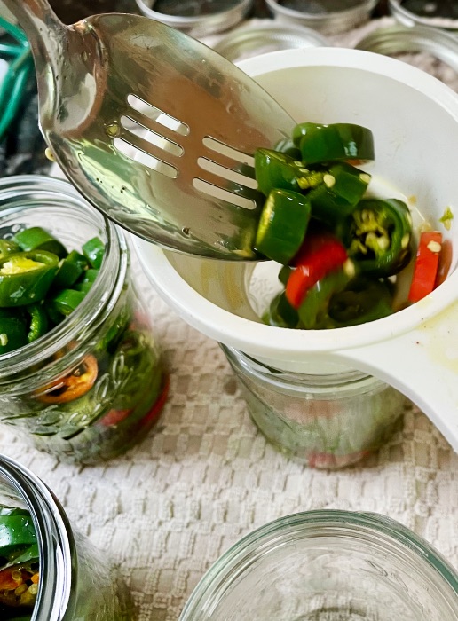 filling jars with candied jalapenos