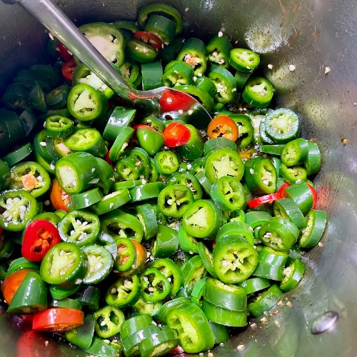 stirring Jalapenos into brine