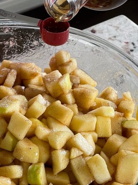 pouring vanilla into apple pie filling