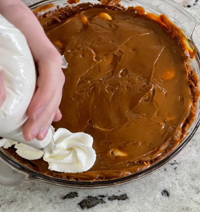 decorating banoffee pie with whipped cream