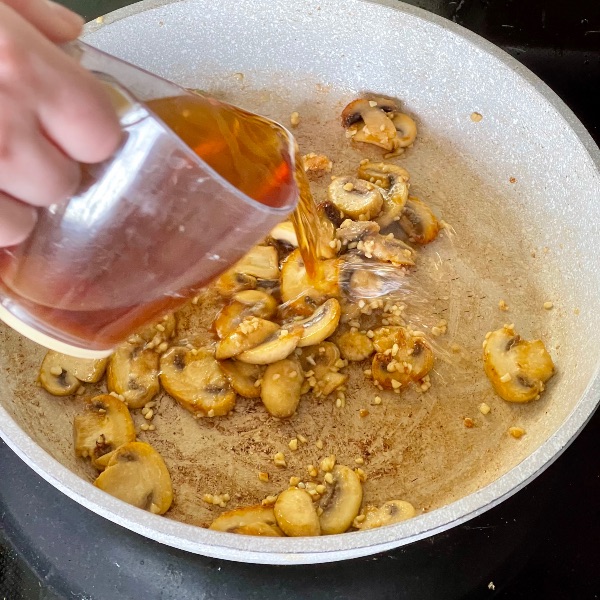 pouring Marsala into browned mushrooms