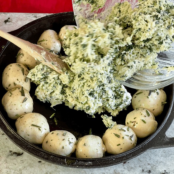 spreading spinach dip into center of cresent ring