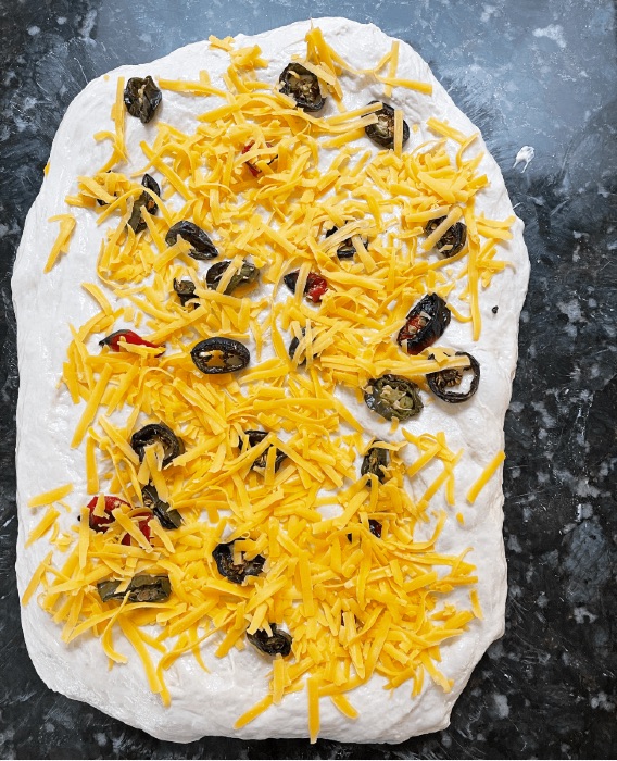 adding filling to dough-dried peppers- sourdough jalape&ntilde;o cheese bread.