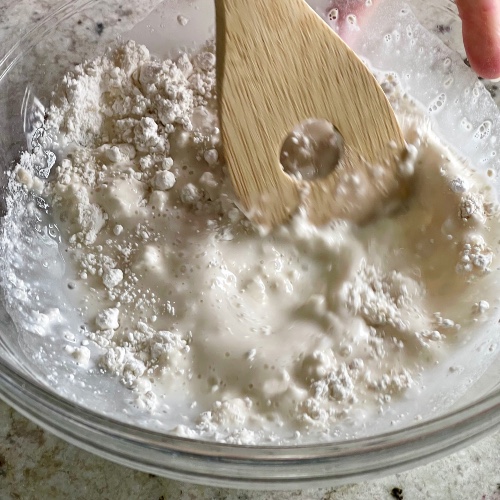 stirring sourdough starter, flour and water