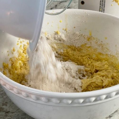adding dry ingredients to eggnog cookie batter