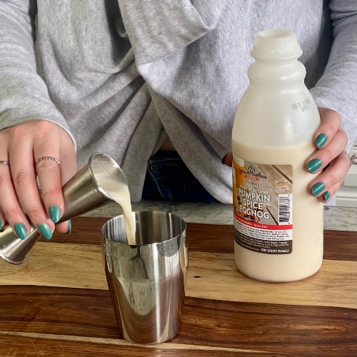 pouring eggnog into cocktail shaker