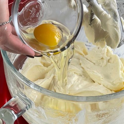 adding eggs into cheesecake batter