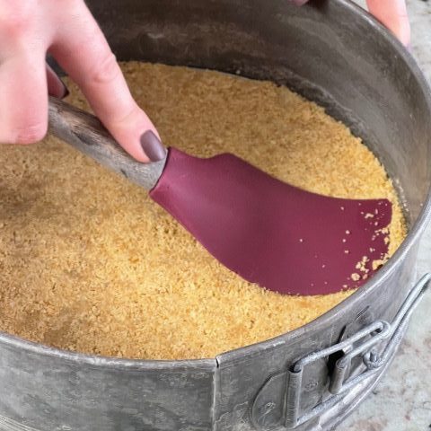 pressing graham cracker pie crust into the pan