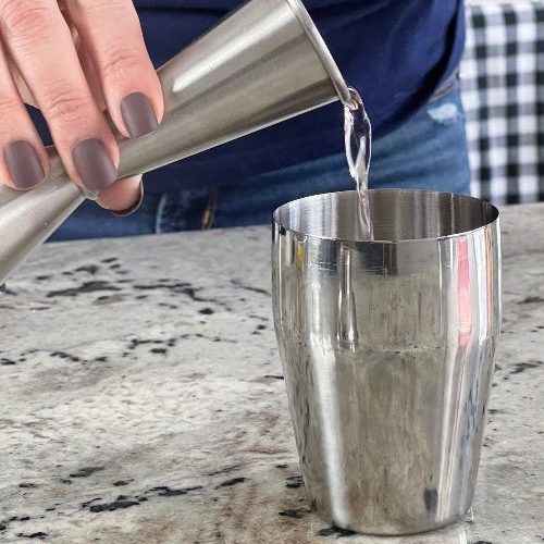 pouring rose gin into shaker