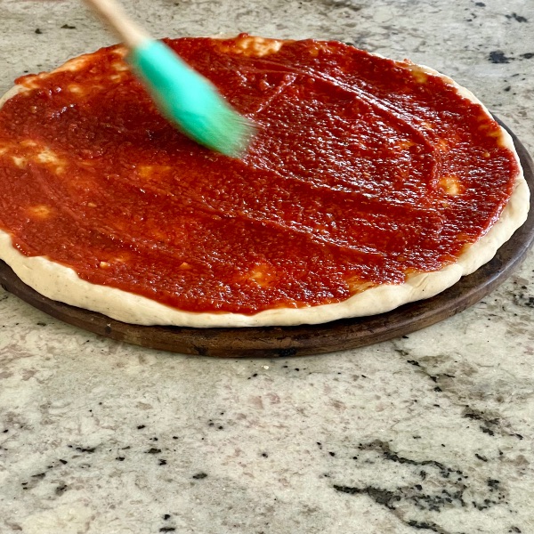 spreading pizza sauce