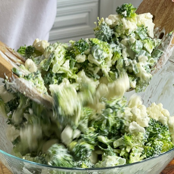 tossing broccoli cauliflower salad