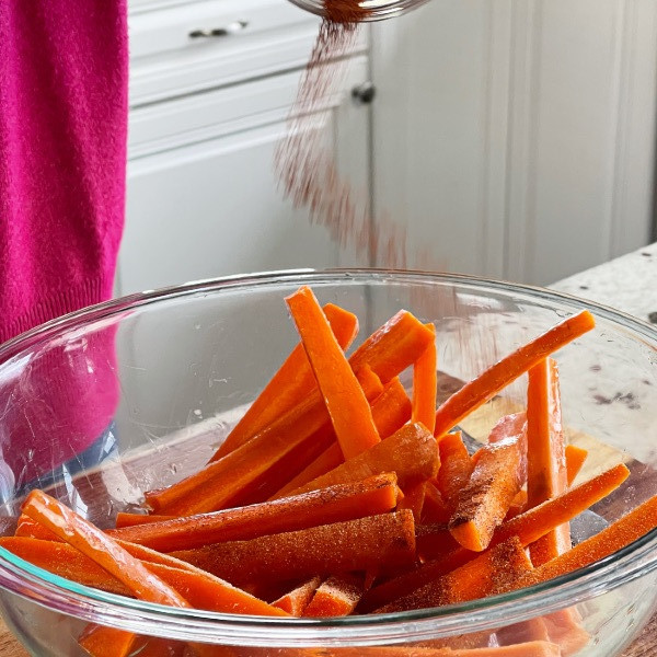 Easy Air Fryer Carrot Fries Recipe 7 seasoning raw carrots in bowl