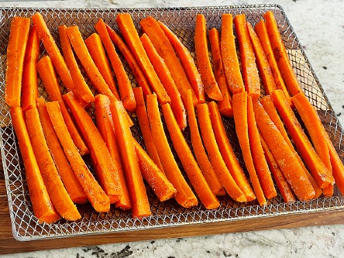 Easy Air Fryer Carrot Fries Recipe 8 raw seasoned carrots on air fryer tray