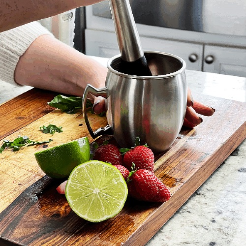 muddling strawberries and basil