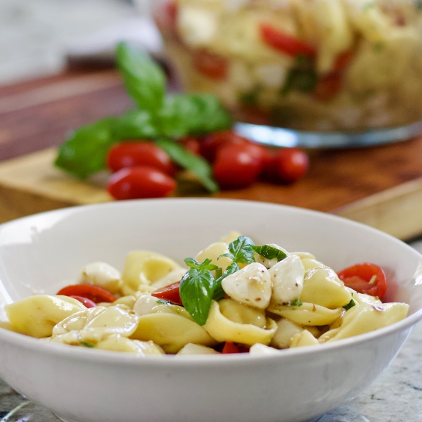 Tortellini Caprese Salad in a white serving bowl