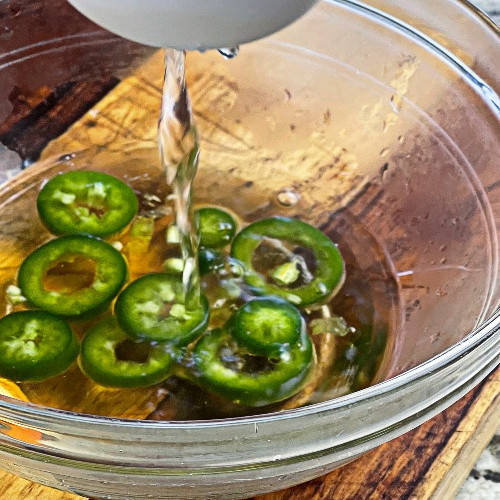 pouring agave nectar over jalape&ntilde;os slices