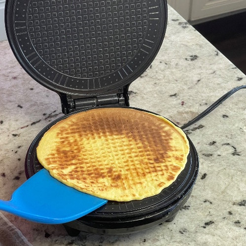 removing cooked waffle from the waffle cone iron