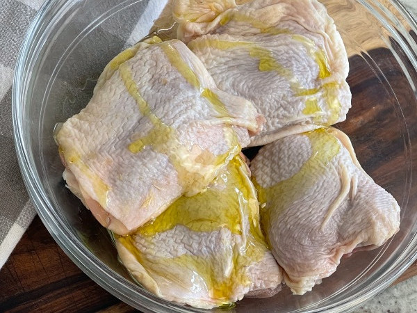 pour olive oil on chicken thighs