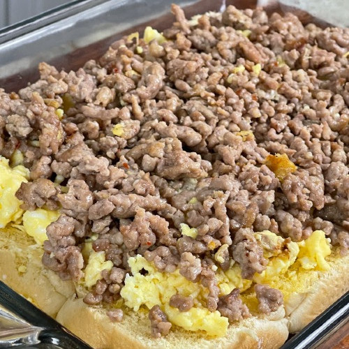 spread sausage on eggs-making breakfast sliders