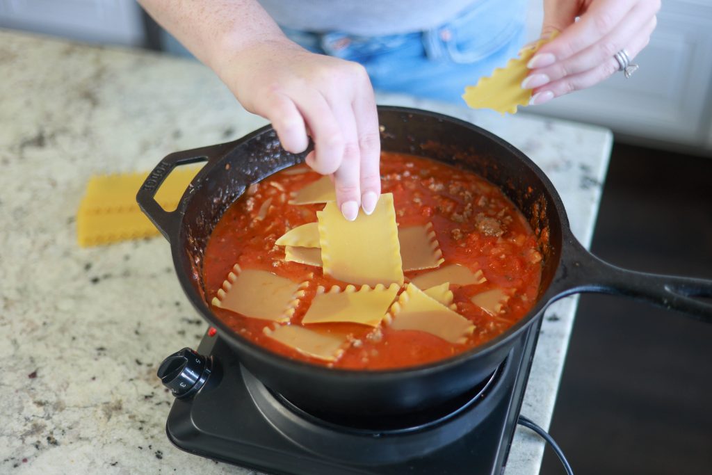 putting noodles in skillet lasagna