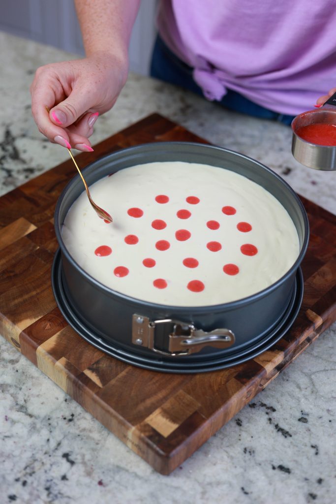 drops of strawberry sauce in cheesecake