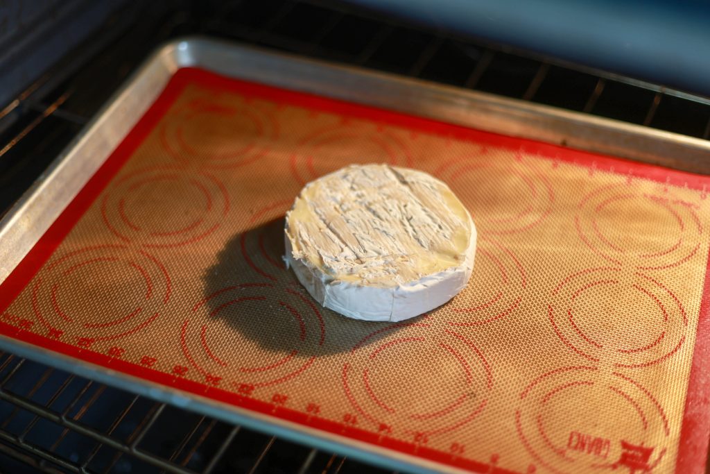 a round brie cheese on a baking sheet