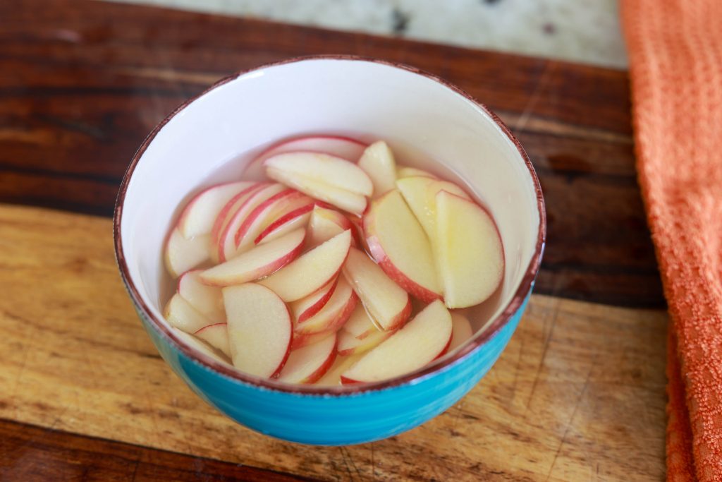 Easy Apple Pie Puff Pastry Tart 3 soaking apple slices in lemon juice and water to prevent browning