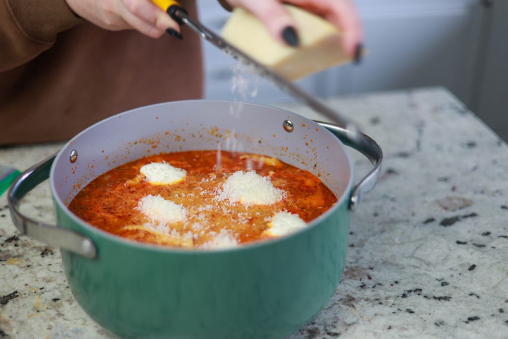 Grating parmesan into cheesy lasagna soup