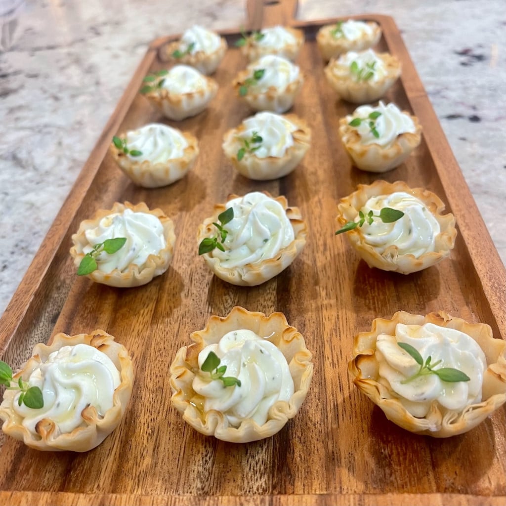 Hot honey whipped  Boursin phyllo cups on a wooden tray