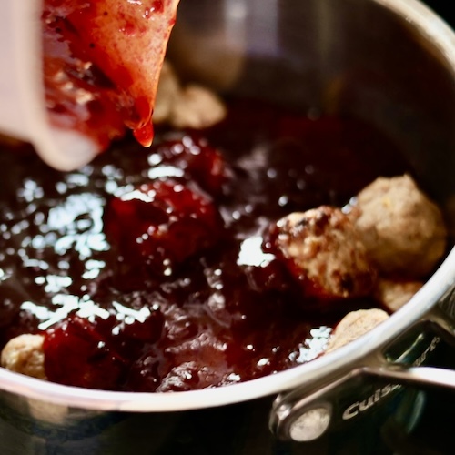 Sizzling Hot Honey Cranberry Meatballs 6 poring sauce over meatballs