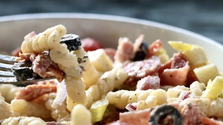 Italian Grinder Pasta Salad. in a white bowl with a fork