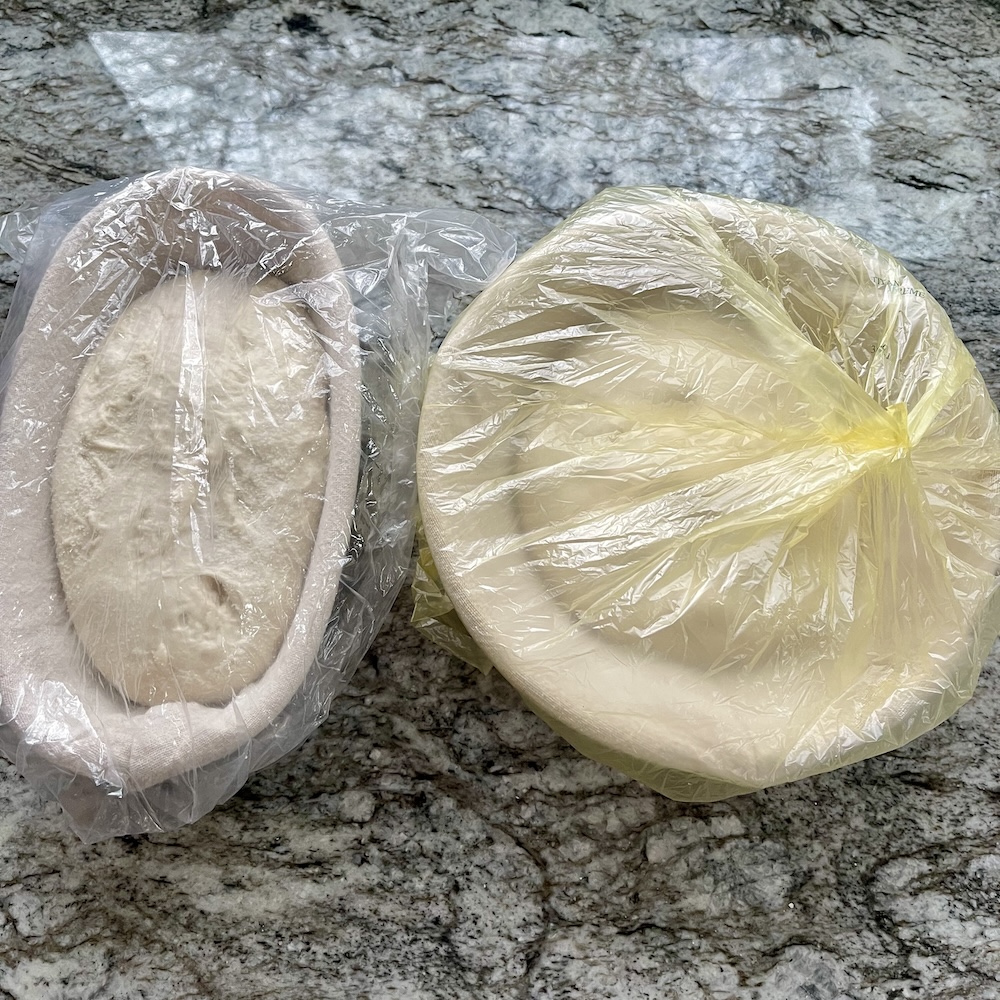 Two sourdough loaves covered for an overnight cold proof in the refrigerator