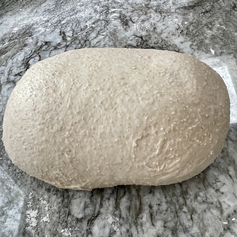 how to shape sourdough bread. a dough showing tears from over stretching