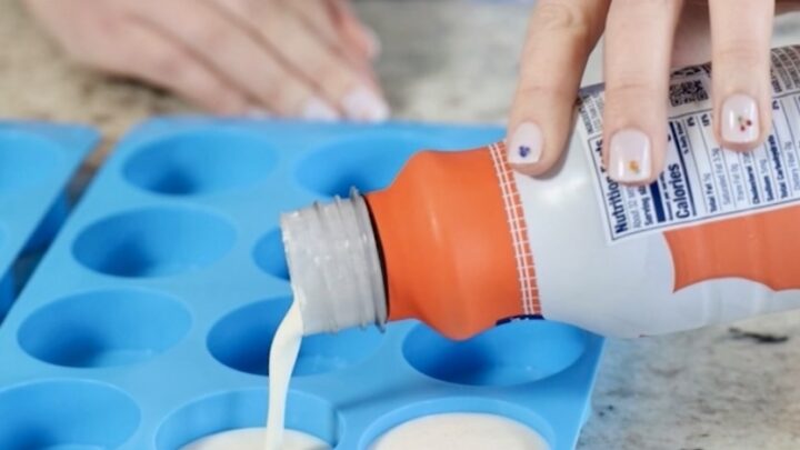 how to freeze heavy cream. pictured is Kayti pouring heavy cream into ice cube trays.